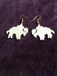 I have beaded these white Buffalo earrings with white delica glass beads. I have added matt black for the Buffalo features. I have crafted these earrings out of white beads but other colors could be used, personalize with the color you want.  I just custom crafted special  colors for my thunder bird pattern that went to Hawaii. Gift White Beaded Earrings With Black Beads, White Dangle Jewelry With Black Beads, White Beaded Earrings As Gift, White Drop Earrings With Black Beads, Nickel-free White Round Bead Earrings, Nickel-free White Beaded Earrings, White Nickel-free Beaded Earrings, White Beaded Earrings With Round Tiny Beads, White And Black Beaded Earrings