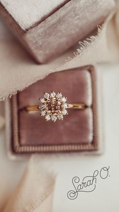 an engagement ring sits on top of a box