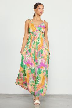 Featuring a long, flowing silhouette that moves gracefully with each step, this maxi dress boasts a sunset-hued tropical print and a surplice-style bodice with pleat detailing. Ruffled straps crisscross the back. A bit of smocking offers a flattering, comfortable fit. •Surplice-style bodice •Ruffled crisscross straps •Pleated waist •Smocked back •Lined Item Number: 99847 100% POLYESTER Beach Season Tropical Print Maxi Dress With Spaghetti Straps, Tropical Maxi Dress For Spring, Tropical Style Spring Maxi Dress, Tropical Flowy Floral Print Maxi Dress, Spaghetti Strap Maxi Dress With Tropical Print For Vacation, Maxi Length Tropical Print Sundress, Spaghetti Straps Maxi Dress With Tropical Print For Vacation, Pink Maxi Dress With Floral Print And Surplice Neckline, Pink Maxi Dress With Surplice Neckline For Beach