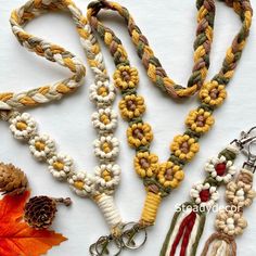 several different types of bracelets are laid out on a white surface with autumn leaves