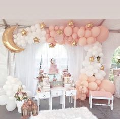 a room filled with balloons and stars on the wall next to a table full of cake