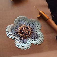 a close up of a table with a pen and brooch