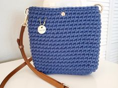 This charming Navy crossbody bag is petite yet roomy.  It's just the right size to hold your everyday essentials for a fuss-free day out.   Lovingly crocheted by hand, this bag is one of a kind. Whether you're stepping out for a casual outing or headed to a chic brunch, this small crossbody bag is ready to compliment any outfit with charm.  This bag is extremely durable and eco-friendly, crocheted with 100% recycled cotton cord.  The brown leather strap is adjustable and the bag includes a magne Navy Crossbody Bag, Leather Gifts For Her, Brown Leather Strap, Navy Leather, Small Crossbody Bag, Boho Bag, Leather Gifts, Crochet Purses, Recycled Cotton