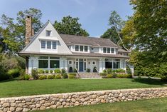 a large white house sitting on top of a lush green field