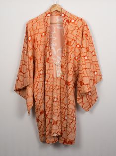 Vintage silk haori with an all-over floral design that is perfect as a summer cover-up - great with jeans and a t-shirt but also dressy enough for a plain sheath dress. A pretty orange haori with an all-over chuu hitta kanoko shibori design of interlocking flowers with a pale pink silk lining that featuring a rangiku (chrysanthemum) print and white hand-braid ties. Rangiku (Spider Chrysanthemum) literally translates as 'rebellious' or 'disordered chrysanthemum' because the long narrow petals hav Casual Silk Kimono For Summer, Casual Silk Spring Kimono, Casual Silk Kimono For Spring, Spring Silk Kimono For Daywear, Spring Cotton Kimono With Batik Print, Cotton Batik Print Kimono For Spring, Spring Floral Print Fitted Kimono, Fitted Floral Print Kimono For Spring, Spring Batik Print Long Sleeve Kimono