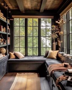 a living room filled with lots of furniture and bookshelves in front of large windows