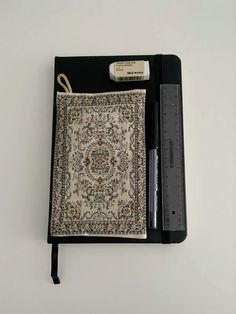 an open notebook with a pen on top of it and a bookmark attached to the cover