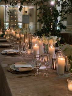 a long table is set with candles and plates for an elegant dinner or party event