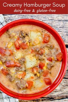 a red bowl filled with creamy hamburger soup on top of a white and brown napkin