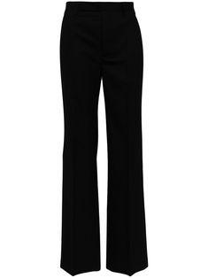 a woman is wearing black pants with high waist and side slits on the legs