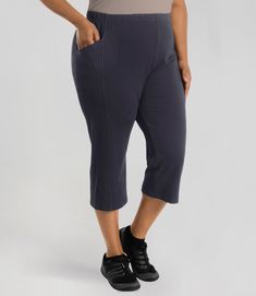 Plus size woman is facing at a side angle Stretch Cotton Capris With Pull-on Style, Capri Length Pants With Side Pockets, Cotton Bottoms With Side Pockets And Capri Length, Relaxed Fit Capris With Side Pockets, Cotton Capri Length Bottoms With Side Pockets, Versatile Cotton Capri Length Bottoms, Athleisure Cotton Capri Bottoms, Comfortable Capri Length Pants With Pockets, Sporty Cotton Capris With Pockets