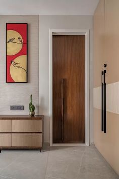 a modern entry way with an art piece on the wall