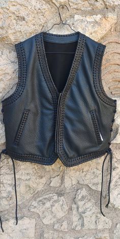 This vest fits anyone who wants to stand up for the crowd. You can choose the colors that match you or your bikers club. The vest is 100% handmade with outstanding quality leather and it comes with a beautiful braid on the edges. Absolutely comfortable and easy to wear. The interior includes excellent quality lining, and 2 big pockets on each side to carry anything you want. Some of my customers order the vest with a hidden pocket in the low back area. You can customize the size of this pocket w Biker Sleeveless Vest For Festivals, Biker Style Fitted Vest For Festivals, Biker Style Sleeveless Vest For Festivals, Fitted Biker Vest For Festivals, Moto Style Sleeveless Vest For Biker Events, Black Biker Vest For Festivals, Leather Sleeveless Vest For Festivals, Sleeveless Leather Vest For Biker Events, Biker Style Leather Vest