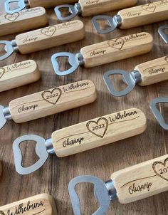 wine bottle openers with names and hearts engraved on them are sitting on a table