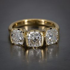 three stone diamond ring in yellow gold with two diamonds on each side and the other side