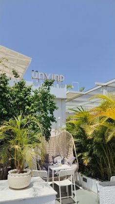 an outdoor seating area with chairs, tables and potted plants in front of the innymp sign