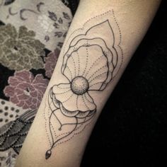 a tattoo on the arm of a woman with a flower in it's center