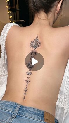 the back of a woman's neck with a flower and heart tattoo on it