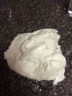 a doughnut that is sitting on top of a granite counter with white icing