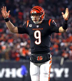 a football player with his hands up in the air while wearing a uniform and number 9