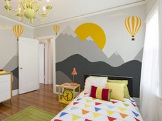 a bedroom decorated in bright colors with hot air balloons painted on the wall