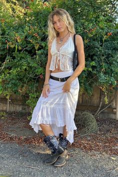 Maxi skirt and cowboy boots outfit, mixed texture outfits, sheer top, thrifted finds from @ruralcollective_est.22 and Mercatopoli in Segrate, Milano, natural curly blonde hair messy look, end of summer look inspo, coastal cowgirl fit White Skirt Cowgirl Outfit, Cowboy Boots Maxi Skirt, Cowboy Boot Festival Outfit, Sheer White Skirt Outfit, All White Festival Outfit, Summer Cowboy Outfit, Long Skirt Cowboy Boots, Cowboy Boots With Skirt, 70s Cowboy Aesthetic