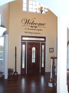 a welcome sign on the side of a door in a room with hardwood floors and walls