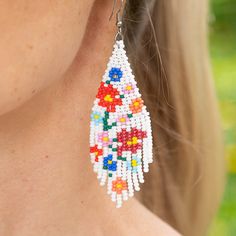 Introducing the Carmen de Viboral Earrings, a stunning homage to the artistry of a charming Colombian town renowned for its exquisite hand-painted china adorned with floral designs. These beautiful earrings feature pristine white beads embellished with vibrant, colorful flower details, all meticulously handwoven with the finest Czech beads. Perfectly capturing the essence of summer, the Carmen de Viboral Earrings add a touch of elegance and warmth to any outfit. Let these exquisite earrings brin White Dangle Flower Earrings For Spring, Traditional White Flower Earrings, Bohemian Beaded Flower Earrings For Wedding, White Bohemian Jewelry With Flower Decoration, Bohemian White Jewelry With Flower Decoration, Multicolor Beaded Flower Earrings For Spring, Spring Multicolor Beaded Flower Earrings, White Dangle Jewelry For Spring, White Flower Earrings With Flower Decoration For Summer