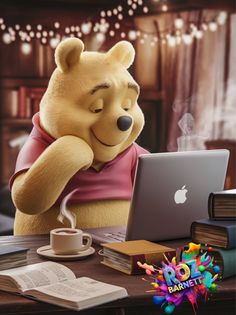 a teddy bear sitting at a desk with a laptop and coffee cup in front of it