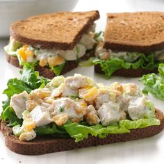 two halves of a sandwich with chicken salad on top and lettuce in the middle