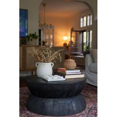 a living room filled with furniture and a large vase on top of a coffee table