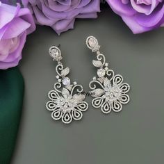 Silver cubic zirconium chandbali earrign with floral design. Inspire your style with this premium quality elegant diamond earring for reception, wedding, cocktail or any other ocassions.  Made with premium quality cubic zirconium diamond in  silver rohodium finish.   All orders Ship same day if placed before 4:00 PM EST  Create beautiful memory for any occasion with elegant jewelry for your loved ones You will receive carefully packaged items in jewelry box, ready to give memorable gift to your Elegant Round Chandelier Earrings For Reception, Diamond Chandelier Earrings With Intricate Design For Parties, Elegant Cubic Zirconia Danglers With Intricate Design, Wedding Danglers With Intricate Design In Cubic Zirconia, Silver Cubic Zirconia Diamond Earrings With Intricate Design, Silver Chandelier Earrings With Intricate Design For Reception, White Cubic Zirconia Chandelier Earrings Gift, Luxury Drop Flower Earrings For Wedding, Silver Chandbali Diamond Earrings For Wedding