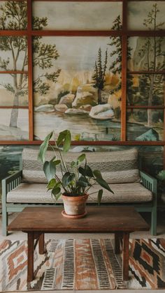 a potted plant sitting on top of a wooden table in front of a painting