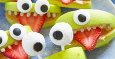 some fruit with googly eyes and strawberries on sticks in the shape of monsters