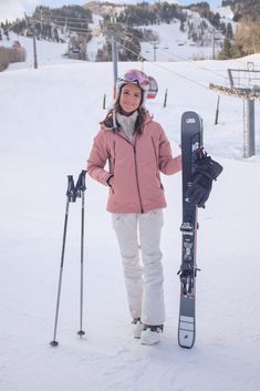 a woman standing in the snow with her skis and poles