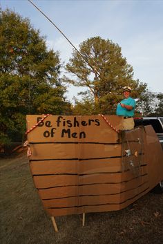 a man standing on the back of a boat made out of cardboard with words that read, be fishers of men