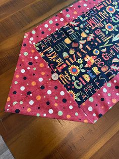 a close up of a piece of fabric on a wooden floor with polka dots and sunflowers