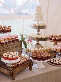 a table topped with lots of cupcakes and cakes