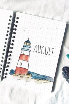 a spiral notebook with the word august written on it next to a seagull