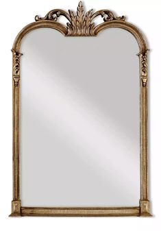 a large mirror with an ornate frame and gold leaf decoration on the top, against a white background