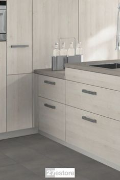 a kitchen with white cabinets and grey counter tops