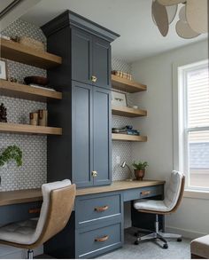 a home office with built - in shelving, desk and chair by the window