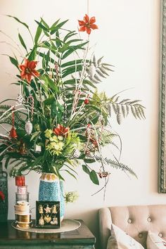 a vase filled with red flowers sitting on top of a table next to a couch