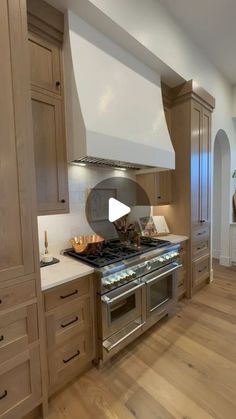 a kitchen with wooden cabinets and stainless steel stove top oven in the center of the room