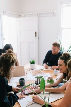 a group of people sitting around a wooden table