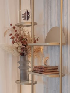 a vase filled with flowers sitting on top of a shelf