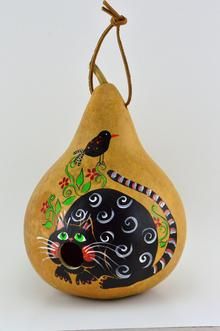 a pear shaped ornament with a black cat painted on it