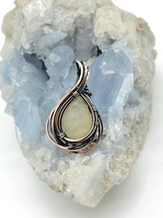 a wire wrapped ring sitting on top of a rock