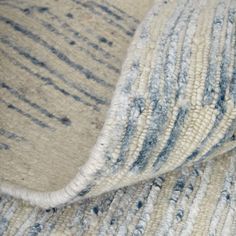 a close up view of a blue and white rug with stripes on the bottom half of it