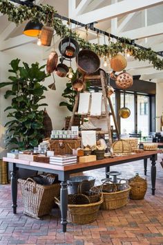 a room filled with lots of pots and pans on top of a wooden table